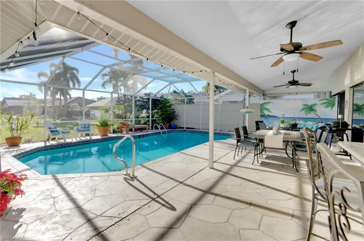 Outdoor pool featuring a patio, outdoor dining area, a lanai, and a sunroom