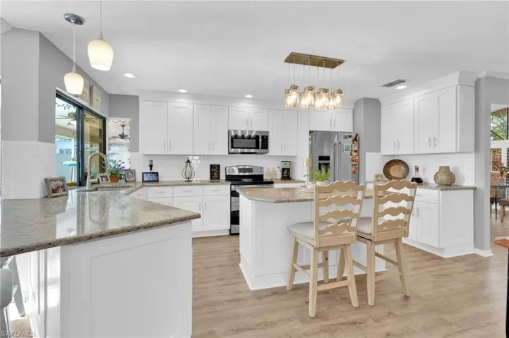 Kitchen featuring a breakfast bar area, healthy amount of natural light, pendant lighting, and recessed lighting