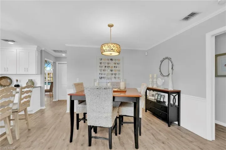 Dining area featuring crown molding and light wood-type flooring