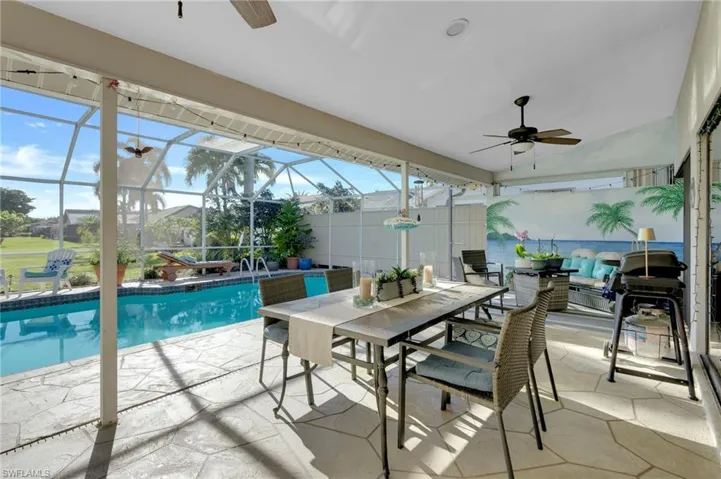 Swimming pool with a patio, outdoor dining area, a sunroom, and glass enclosure
