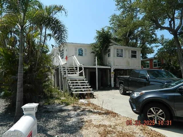 View of front of property with driveway and stairway