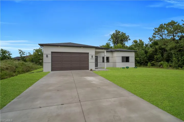 Contemporary exterior with a dark brown paneled garage door, concrete driveway, and a manicured lawn
