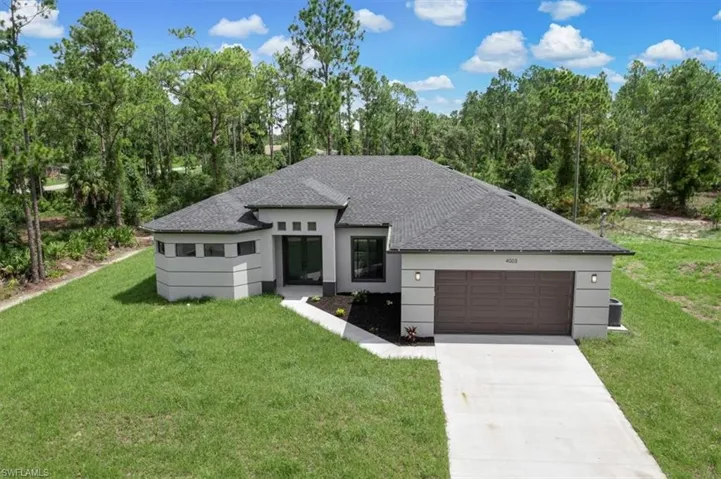 View of front of home with a garage and a front yard