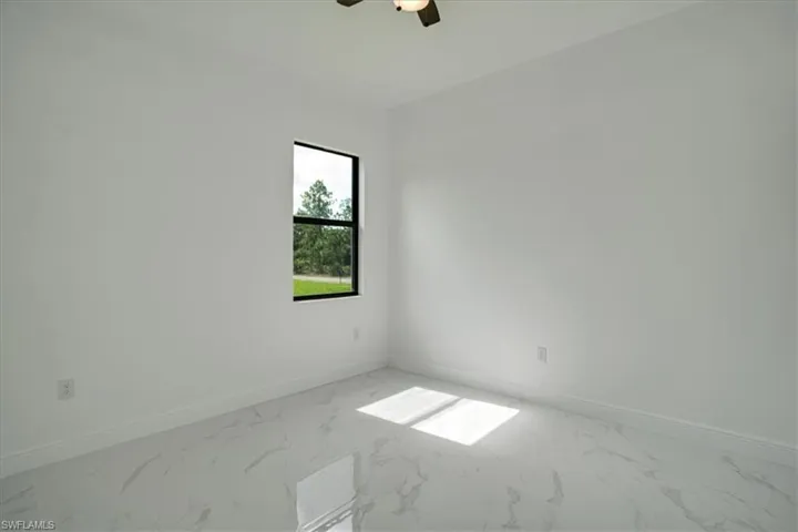 Tiled empty room featuring ceiling fan