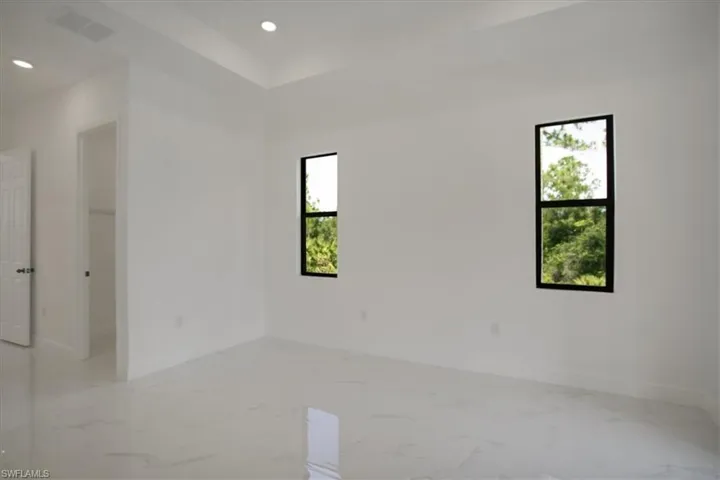 Unfurnished room with tile flooring and a wealth of natural light