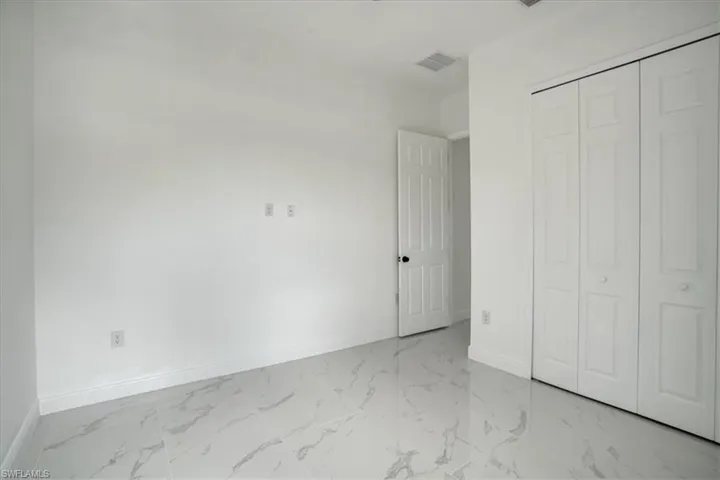 Unfurnished bedroom featuring a closet and light tile floors