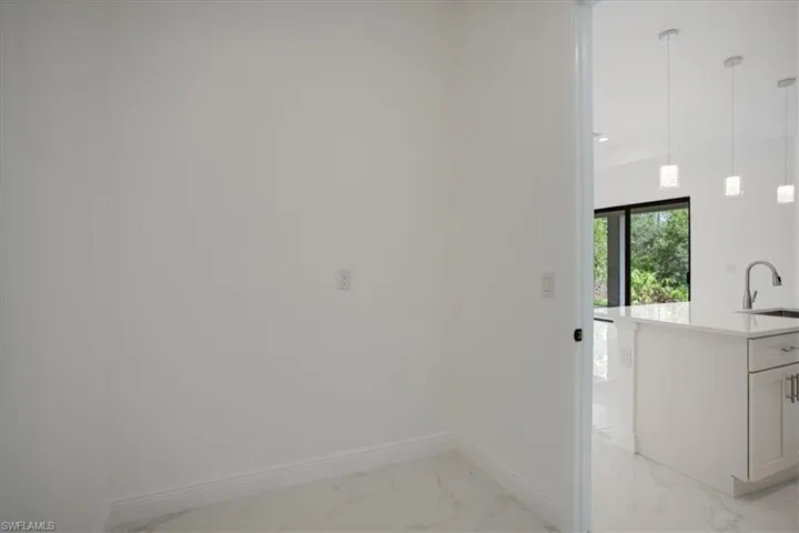 Laundry room with sink and light tile flooring