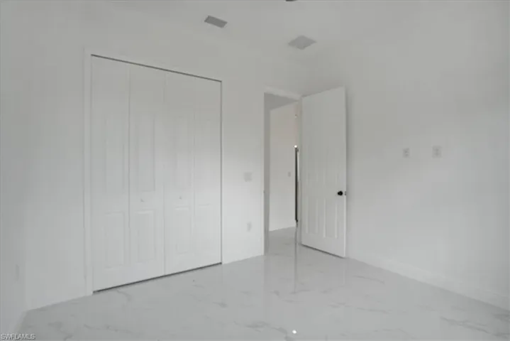 Unfurnished bedroom featuring a closet and light tile flooring