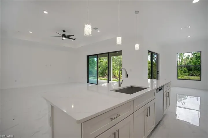 Kitchen with a wealth of natural light, sink, and an island with sink