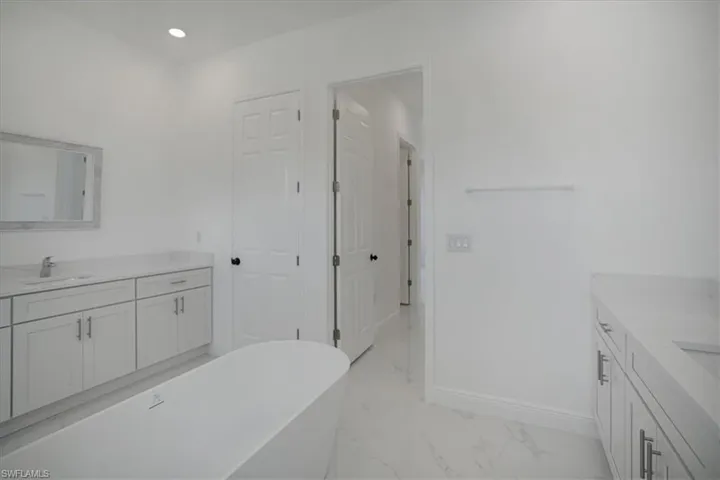 Bathroom with tile floors, a bathtub, and vanity