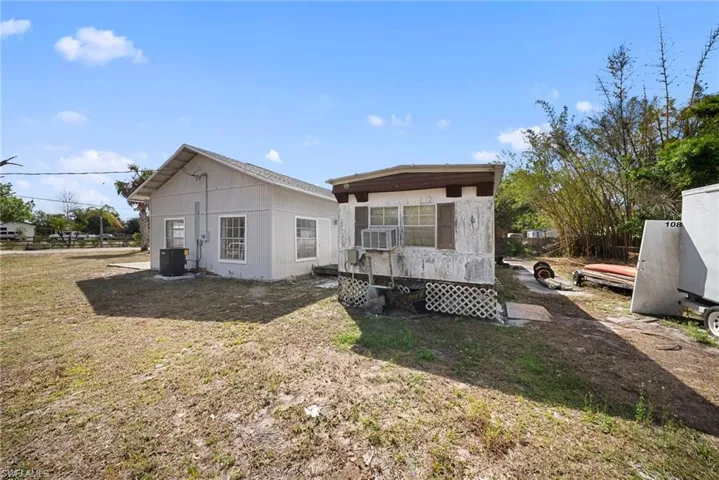 Rear view of house with a deck and a lawn
