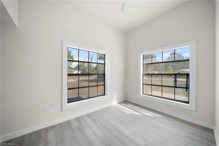 Empty room featuring baseboards and light wood-style flooring