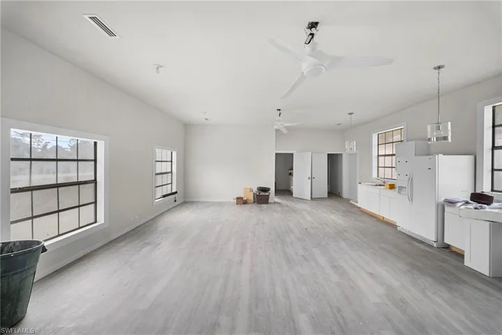 Unfurnished living room featuring light wood-style floors and ceiling fan