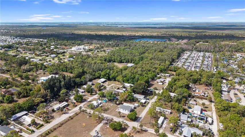 Aerial view of residential area with a heavily wooded area and a large body of water