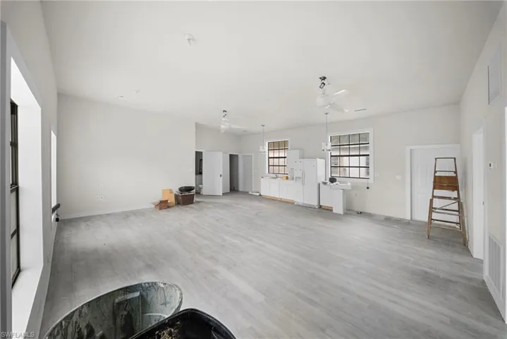 Unfurnished living room with ceiling fan and light wood-type flooring