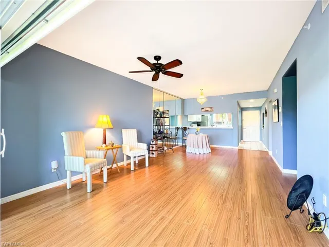 Living area with light hardwood / wood-style floors and ceiling fan