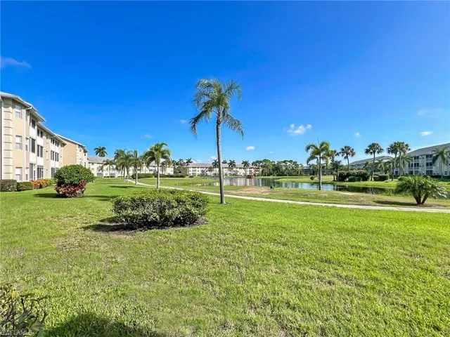 Surrounding community with a water view and a lawn