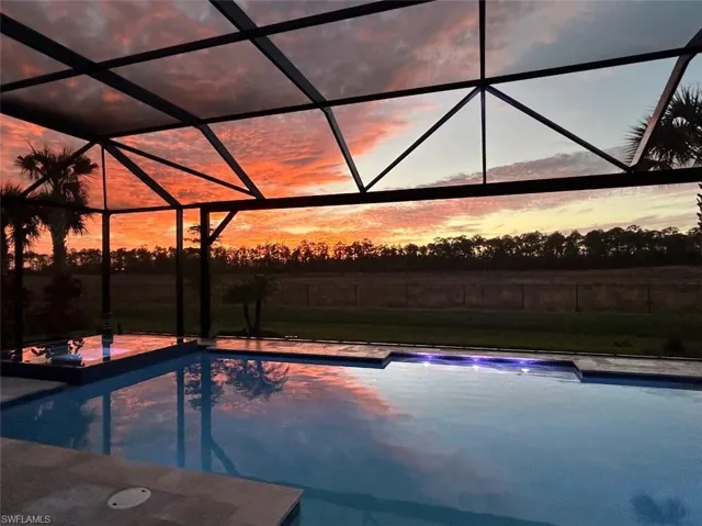 Pool at dusk with a lanai