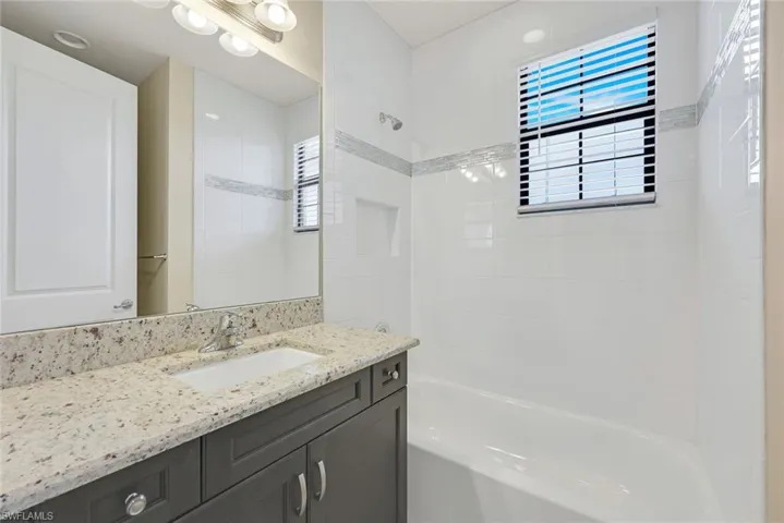Upstairs Bathroom 1 with tiled shower / bath combo and quartz vanity