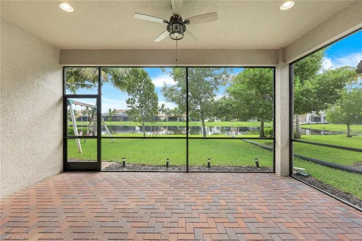 Screened in patio featuring a lake water view and ceiling fan