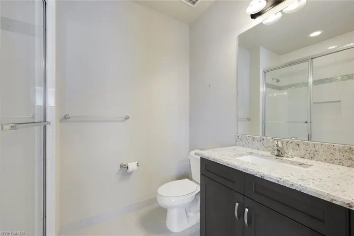 Upstairs Bathroom 2 featuring walk in shower and quartz vanity
