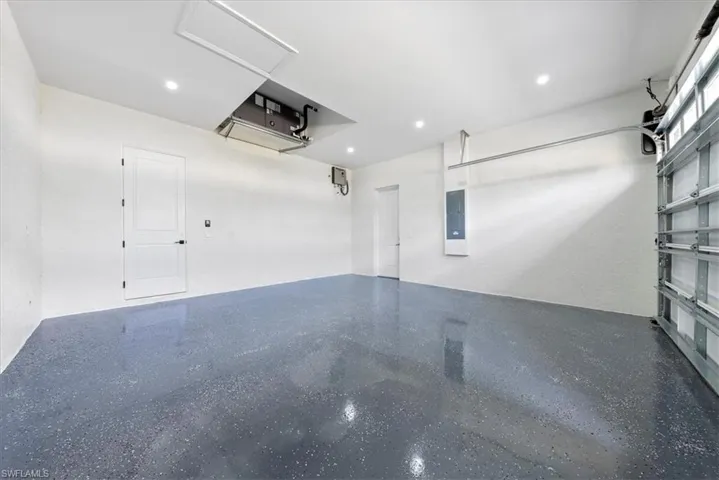 Garage with electric panel and recessed lighting