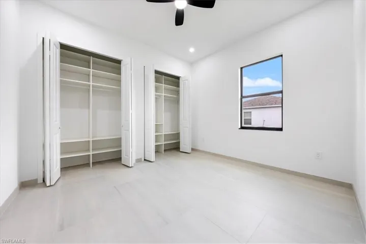 Unfurnished bedroom with multiple closets, recessed lighting, a ceiling fan, baseboards, and tile patterned floors