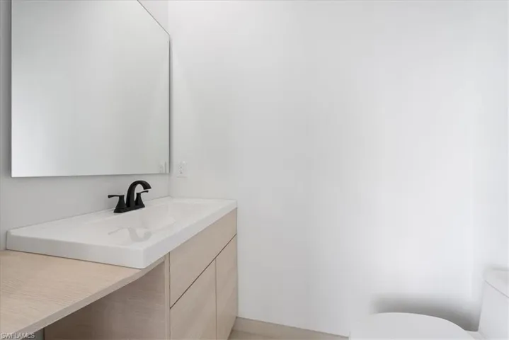 Half bathroom featuring vanity and toilet