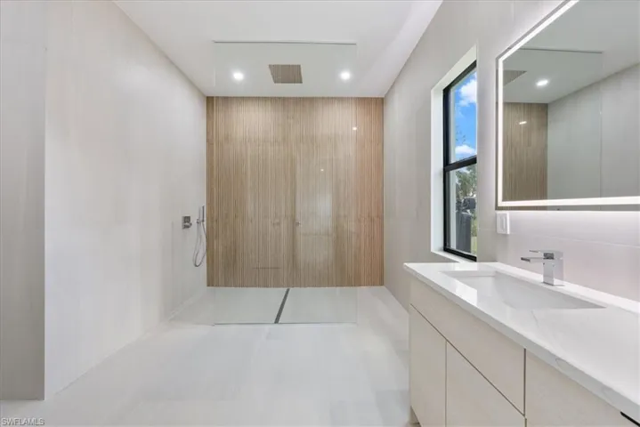 Full bath with tile walls, vanity, and walk in shower