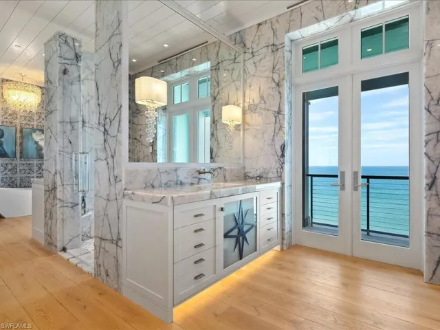 Full bath featuring vanity, stone wall, and light wood-style floors