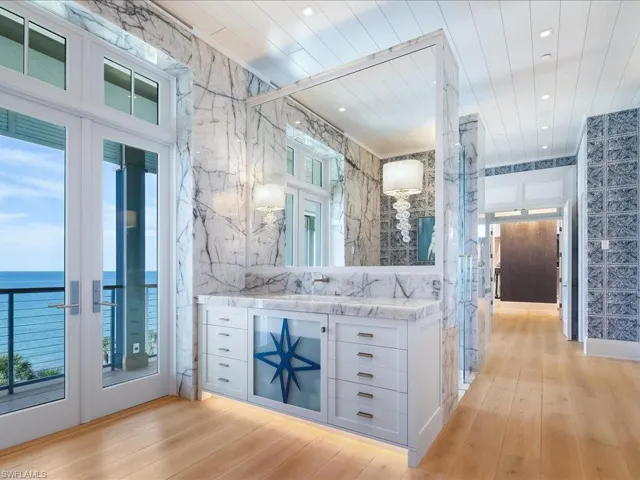 Bathroom featuring vanity, french doors, light wood-type flooring, recessed lighting, and a water view