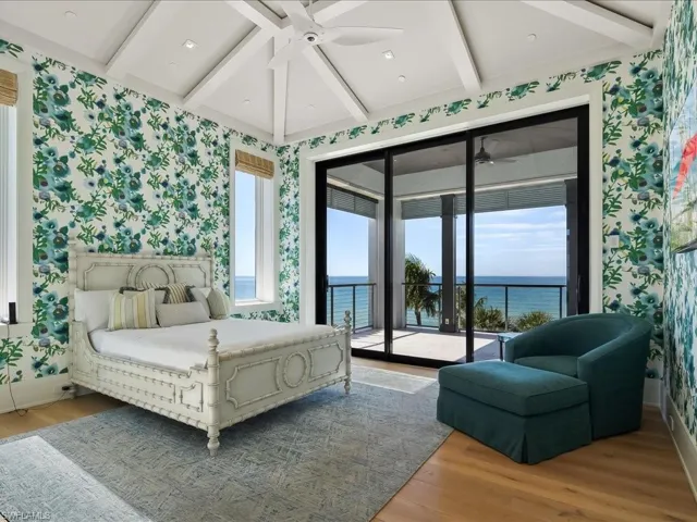 Bedroom with wallpapered walls, beam ceiling, access to exterior, light wood-style flooring, and a ceiling fan
