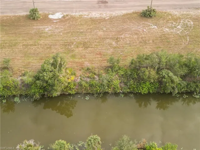 Drone / aerial view from across the canal, the back of the lot looking towards the street