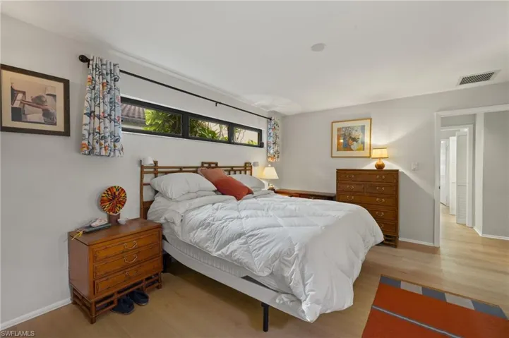Bedroom with light wood-style floors, baseboards, and visible vents