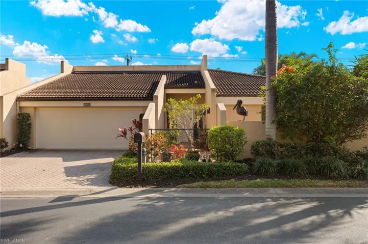 View of front of house featuring decorative driveway, a tile roof, and stucco siding