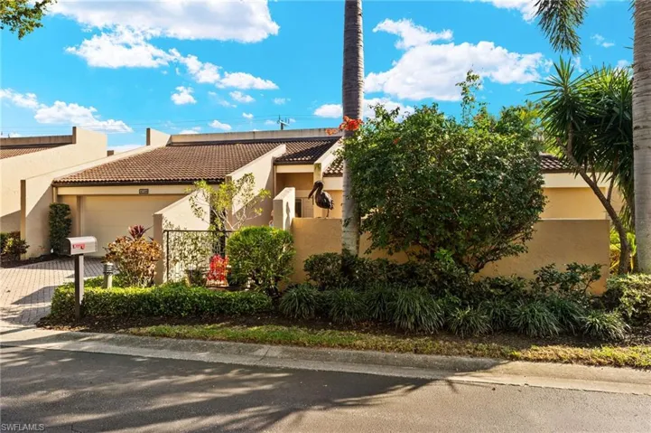View of front of home with decorative driveway, a tile roof, an attached garage, and stucco siding