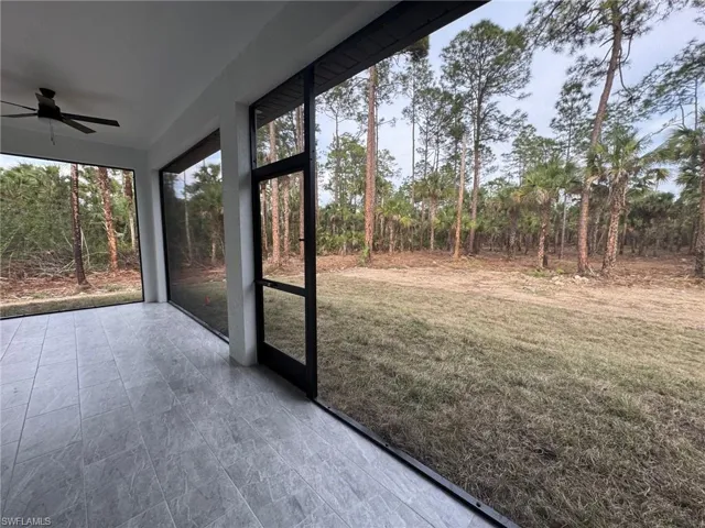 Unfurnished sunroom featuring ceiling fan