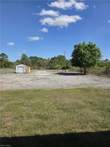 View of yard with a detached garage and driveway