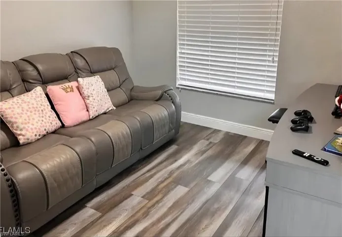 Living room featuring baseboards and light wood-style floors