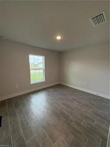 Empty room featuring recessed lighting and wood tiled floors