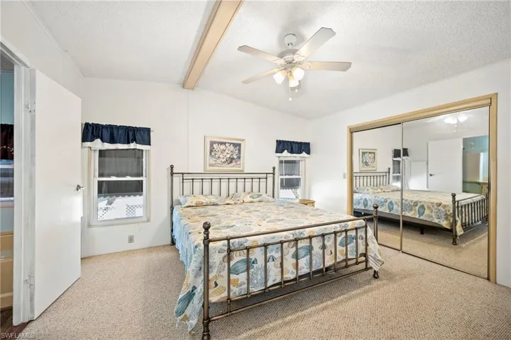 Carpeted bedroom featuring ceiling fan, a closet, and a textured ceiling
