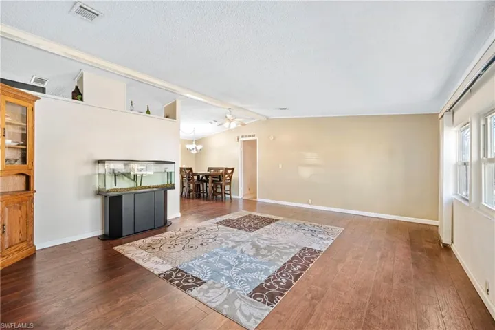 Living area with wood finished floors, a textured ceiling, and a ceiling fan