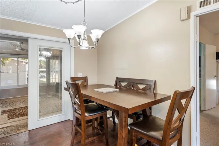 Dining room with ornamental molding, a textured ceiling, and a chandelier