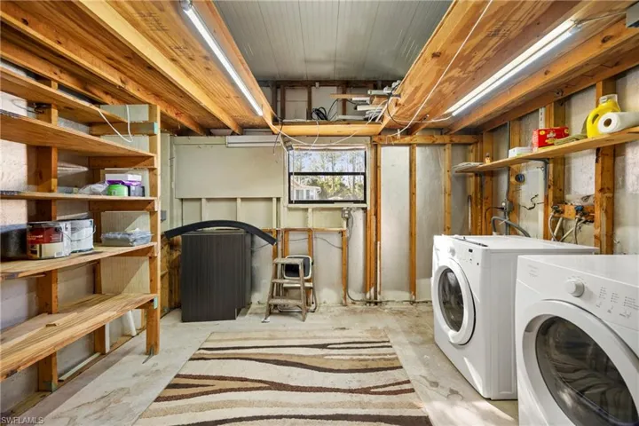 Laundry area featuring concrete flooring and washing machine and dryer