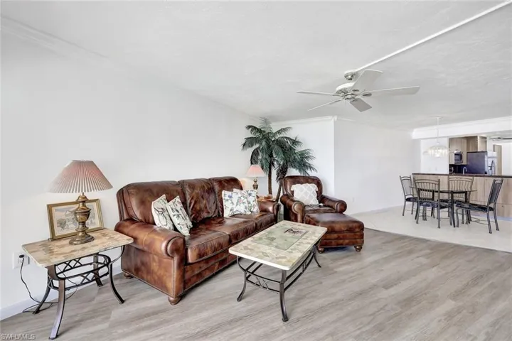 Living area featuring light wood-type flooring, ceiling fan, and crown molding