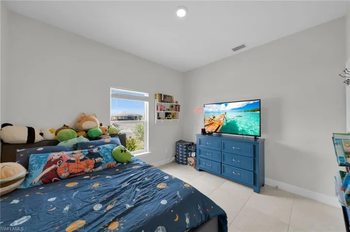 Bedroom with baseboards and light tile patterned floors