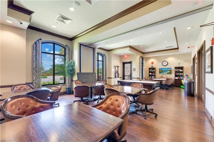 Home office featuring wood-type flooring, a raised ceiling, plenty of natural light, and ornamental molding