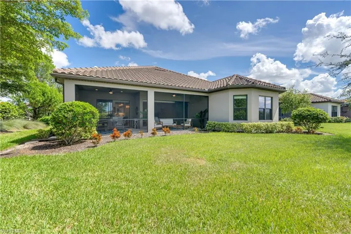 Rear view of property with a yard and a sunroom
