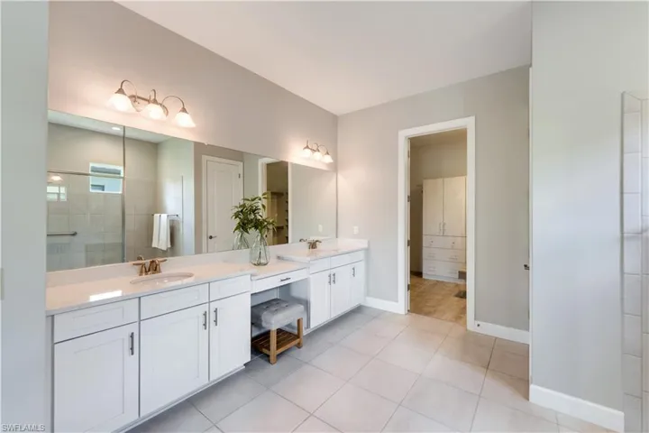 Bathroom featuring vanity, tile patterned flooring, and a tile shower