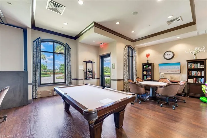Rec room with a healthy amount of sunlight, dark hardwood / wood-style floors, and billiards